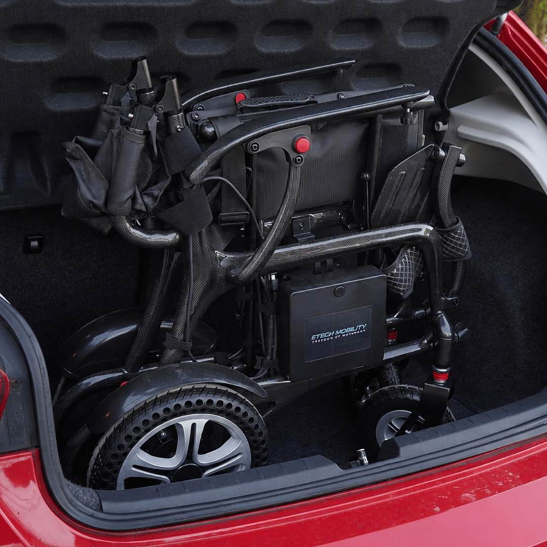 Atlas HD lightweight folding carbon fibre electric wheelchair compactly folded in a small car boot by Etech Mobility