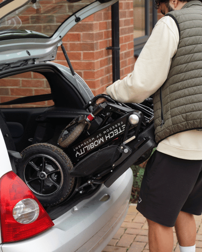 Lightweight, folded, electric wheelchair by Etech Mobility easily lifted and stored in the boot of small vehicle. 
